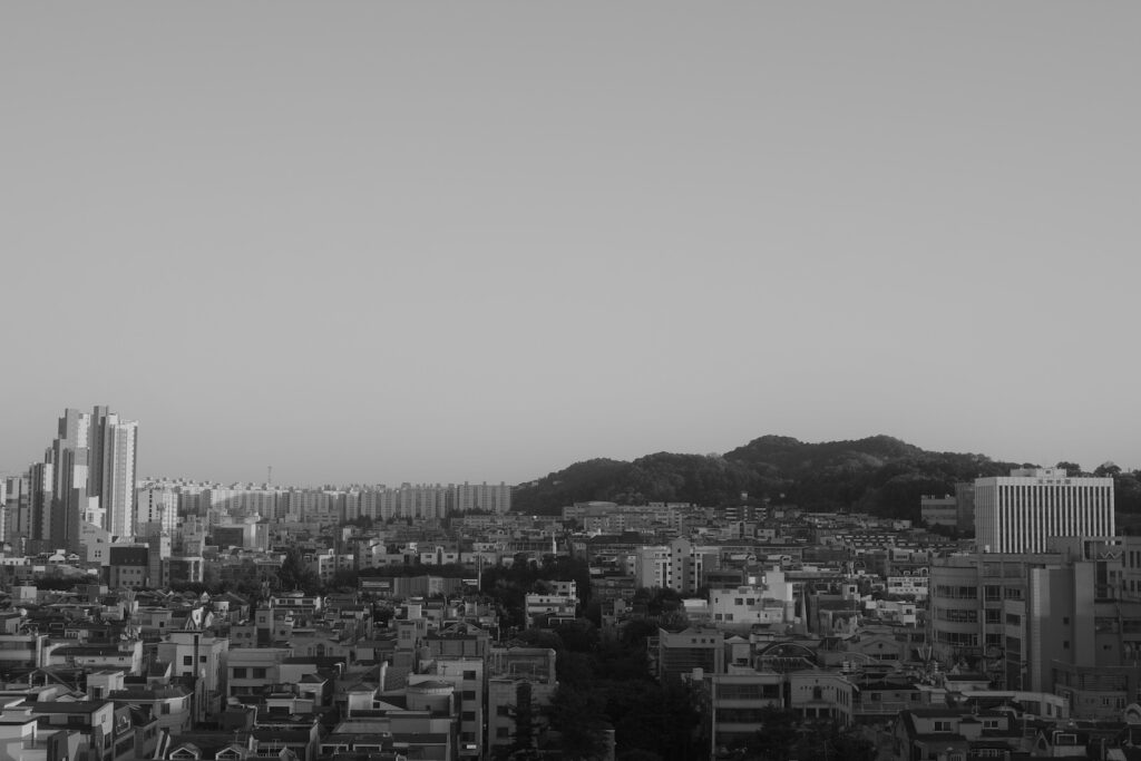 리코 GR4로 흑백 촬영한 건물과 언덕이 이어진 도시 풍경