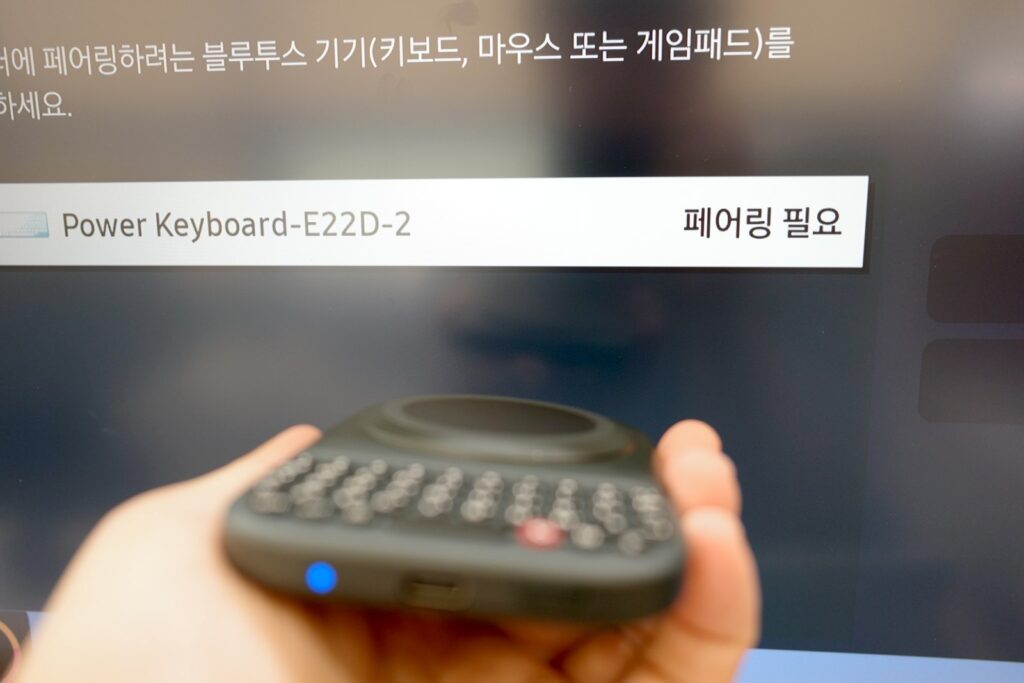 스마트TV의 블루투스 검색 화면에 잡힌 Power Keyboard와 리모컨처럼 한 손에 쥔 클릭스 파워 키보드
